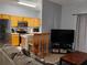 Open living space with a kitchen bar, dining area, and comfortable seating around a television at 247 Verona Ave, Davenport, FL 33897