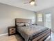 This bedroom features a ceiling fan and gray walls, along with a door to the outside balcony area at 247 Verona Ave, Davenport, FL 33897