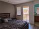 Comfortable main bedroom with a large window, dark wood floors, and an exterior balcony at 247 Verona Ave, Davenport, FL 33897