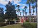 View of a lush pool area with palm trees and a red-railed bridge on a sunny day at 247 Verona Ave, Davenport, FL 33897