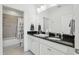 Bathroom with double granite vanity, white cabinets, tile flooring and view to a shower and toilet at 256 Captiva Dr, Davenport, FL 33896