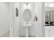 Well-lit half bath featuring pedestal sink and decorative mirror at 256 Captiva Dr, Davenport, FL 33896