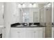 Bathroom featuring a double sink vanity with black granite countertop and tiled shower at 256 Captiva Dr, Davenport, FL 33896