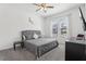 Cozy bedroom with a gray upholstered bed, ceiling fan, and natural light from a window at 256 Captiva Dr, Davenport, FL 33896