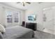 Sunlit bedroom with a large window, TV, and plush gray carpet at 256 Captiva Dr, Davenport, FL 33896