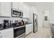 Modern kitchen with stainless steel appliances, black countertops, and white cabinets at 256 Captiva Dr, Davenport, FL 33896