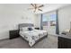 Bright main bedroom with two windows, ceiling fan, a gray bed frame and floral print bedspread at 256 Captiva Dr, Davenport, FL 33896