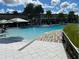 Resort-style pool and sundeck with palm trees, umbrellas, and comfortable lounge chairs for relaxation at 256 Captiva Dr, Davenport, FL 33896