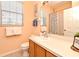 This bathroom features a sink with a mirror, toilet, shower, and window with blinds at 2778 Almaton Loop # 403, Kissimmee, FL 34747