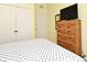 This bedroom features a wooden dresser with a mounted television, a closet, and a door at 2778 Almaton Loop # 403, Kissimmee, FL 34747