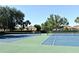 View of well-maintained tennis courts with green and blue surfaces surrounded by trees and residential buildings at 2778 Almaton Loop # 403, Kissimmee, FL 34747