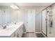 Bathroom featuring double sinks, a white countertop, a glass door shower, and gray plank flooring at 2821 Cathy Blvd, Winter Haven, FL 33880