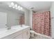 Well-lit bathroom featuring a double sink vanity, modern fixtures, and a shower/tub combo with decorative curtain at 2821 Cathy Blvd, Winter Haven, FL 33880
