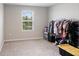 Simple bedroom featuring a window with natural light, neutral carpet, and a storage rack at 2821 Cathy Blvd, Winter Haven, FL 33880