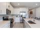 Bright kitchen with stainless steel appliances, white cabinets, an island, and wood-look flooring at 2821 Cathy Blvd, Winter Haven, FL 33880