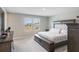 Spacious main bedroom featuring a king bed, bench, plush carpet and serene view from the bright double window at 2821 Cathy Blvd, Winter Haven, FL 33880