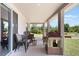 A covered porch with chairs, a playhouse, and view of a backyard pond at 2821 Cathy Blvd, Winter Haven, FL 33880
