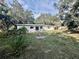 Expansive backyard with a large lawn, mature trees, and a patio area, perfect for outdoor entertaining at 2831 Magnolia Ave, Sanford, FL 32773
