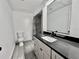 Modern bathroom showcasing a vanity with black countertop, white cabinetry, and a sleek, frameless mirror at 2831 Magnolia Ave, Sanford, FL 32773