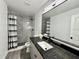 Stylish bathroom featuring a vanity with a dark countertop, light gray shower tile, and sleek black fixtures at 2831 Magnolia Ave, Sanford, FL 32773
