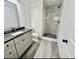 Elegant bathroom featuring a shower with modern tile, and a dark countertop over white cabinets at 2831 Magnolia Ave, Sanford, FL 32773