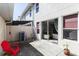 Private back patio with sliding glass doors, red chair, and minimalist landscaping at 2901 Puerta Del Sol Blvd, Kissimmee, FL 34744
