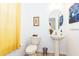 Bright bathroom with a pedestal sink, toilet, decorative mirror, and artistic wall decor providing a modern aesthetic at 2901 Puerta Del Sol Blvd, Kissimmee, FL 34744