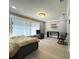 Bright bedroom featuring hardwood floors, natural light from the window, modern light fixture, and an accent chair at 3328 Wax Berry Ct, Windermere, FL 34786