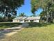 Charming single-story home featuring a well-manicured lawn, a stone facade and a paved driveway at 3328 Wax Berry Ct, Windermere, FL 34786