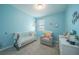 Bedroom with blue walls, crib, chair, and dresser at 3451 Monaco Ln, Davenport, FL 33897