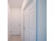Bright hallway featuring tile flooring and white paneled doors, creating a clean and simple design at 3451 Monaco Ln, Davenport, FL 33897