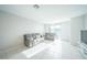 Bright living room features neutral paint, tile flooring, and modern gray sofa and loveseat set at 3451 Monaco Ln, Davenport, FL 33897