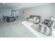Open-concept living space with kitchen island, gray sofas, and large windows for natural light at 3451 Monaco Ln, Davenport, FL 33897