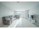Bright living room features neutral paint, tile flooring, and modern gray sofa and loveseat set at 3451 Monaco Ln, Davenport, FL 33897