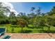 Lush backyard showing brick patio and view of manicured green grass and plentiful trees at 3890 Prairie Reserve Blvd, Orlando, FL 32824