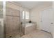Bathroom featuring a glass-enclosed shower, bathtub, and tiled walls at 3890 Prairie Reserve Blvd, Orlando, FL 32824