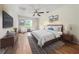 Comfortable bedroom with hardwood flooring, ceiling fan, a large window, and stylish decor at 3890 Prairie Reserve Blvd, Orlando, FL 32824