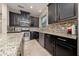 Modern kitchen featuring dark cabinetry, stainless steel appliances, tile backsplash, and granite countertops at 3890 Prairie Reserve Blvd, Orlando, FL 32824