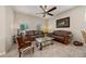 Inviting living room with tile flooring, bright windows, ceiling fan, and a comfortable leather sofa at 3890 Prairie Reserve Blvd, Orlando, FL 32824