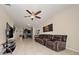 Cozy living room featuring tile flooring, a ceiling fan, and dark leather seating with lots of natural light at 3890 Prairie Reserve Blvd, Orlando, FL 32824