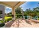 Outdoor patio with brick flooring, seating area, and lush backyard views at 3890 Prairie Reserve Blvd, Orlando, FL 32824