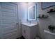Bathroom with a vanity with a backlit mirror, and a toilet with decorative shelves above at 400 Chayne Pl, St Cloud, FL 34771
