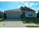 Attractive single-story home featuring a two-car garage, modern design elements, and pristine landscaping at 400 Chayne Pl, St Cloud, FL 34771