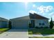 Well-kept home featuring a two-car garage, mature landscaping, and modern architectural details at 400 Chayne Pl, St Cloud, FL 34771