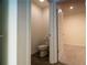 This powder room has a toilet with a gray wood-look floor and is conveniently located near another room at 400 Chayne Pl, St Cloud, FL 34771
