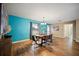 Elegant dining room with wood floors, a modern dining table, turquoise accent wall, and stylish decor at 4091 Lippman Rd, St Cloud, FL 34772
