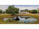 Scenic property featuring a pond with lily pads and a home with a well-maintained lawn and mature trees at 4091 Lippman Rd, St Cloud, FL 34772