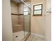 Tiled shower featuring a glass door, corner seat, and modern fixtures at 4091 Lippman Rd, St Cloud, FL 34772