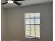 Cozy bedroom with a window offering natural light, complemented by a ceiling fan and neutral decor at 414 Otter Creek Dr, Kissimmee, FL 34743