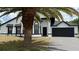 Charming single-Gathering home featuring a clean white exterior and dark accents, along with an attached two-car garage at 414 Otter Creek Dr, Kissimmee, FL 34743
